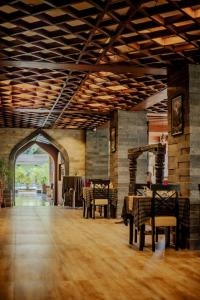 ein großes Zimmer mit Tischen und Stühlen und einer Steinmauer in der Unterkunft Hotel Bhadgaon in Bhaktapur