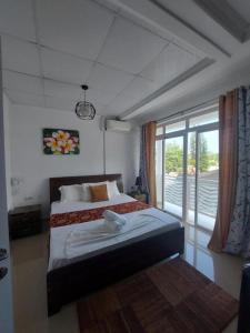 a bedroom with a bed and a large window at Diamond Plaza in Grand Anse