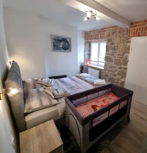 a bedroom with a bed and a couch in it at Apartman Orhideja in Fužine
