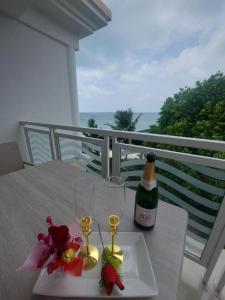 einen Tisch mit zwei Gläsern und einer Flasche Wein in der Unterkunft Diamond Plaza in Grand Anse