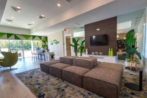uma grande sala de estar com um sofá e uma televisão em Modern 4 Bedrooms Vacation Home with Splash Pool at Le Reve Resort (4435) em Kissimmee