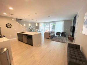 uma ampla sala de estar com uma cozinha e uma sala de estar em Modern 4 Bedrooms Vacation Home with Splash Pool at Le Reve Resort (4435) em Kissimmee