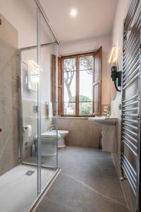 a bathroom with a shower and a toilet and a sink at Hotel Villa Maya in Cascina