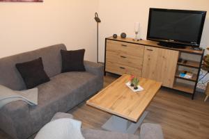 ein Wohnzimmer mit einem Sofa und einem TV in der Unterkunft Ferienwohnung Krümel in Emden