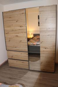 duża drewniana szafka w pokoju z łóżkiem w obiekcie Ferienwohnung Krümel w mieście Emden