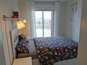 1 dormitorio con 1 cama y puerta con ventana en Apartment BELLA VISTA, en Los Narejos