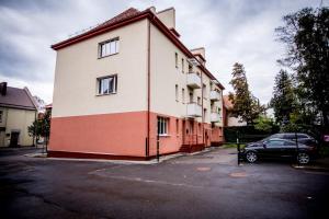 a building with a car parked in a parking lot at Liepu 37 in Klaipėda