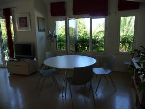 einen Tisch und Stühle in einem Zimmer mit Fenstern in der Unterkunft Appartement Ranavalo Pays Basque in Anglet