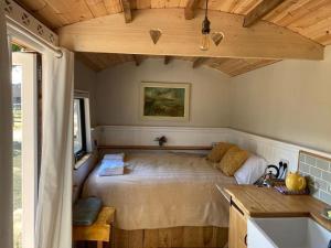 um quarto com uma cama no canto de um quarto em Aspen Leaves: The perfect farm retreat em Graffham