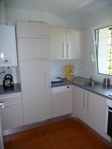 cocina con armarios blancos, fregadero y ventana en Appartement Ranavalo Pays Basque, en Anglet