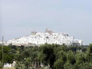 un gran edificio blanco en la cima de una colina en La Casodda en Ostuni