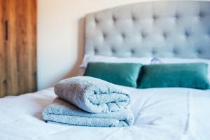 a pile of towels sitting on top of a bed at Oakley Place - Room C Deluxe Ensuite in Bristol