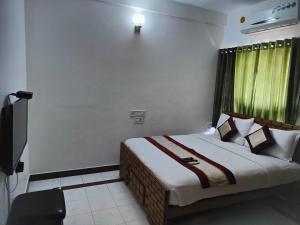 a bedroom with a bed and a television in it at Kapsstone HOMESTAY- Apartments &Rooms near APOLLO &SHANKARA NETHRALAYA HOSPITALS -Greams Road in Chennai