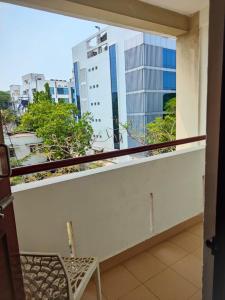 a balcony with a chair and a view of a city at Kapsstone HOMESTAY- Apartments &Rooms near APOLLO &SHANKARA NETHRALAYA HOSPITALS -Greams Road in Chennai