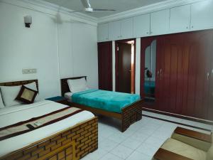 um quarto de hotel com duas camas em Kapsstone HOMESTAY- Apartments &Rooms near APOLLO &SHANKARA NETHRALAYA HOSPITALS -Greams Road em Chennai
