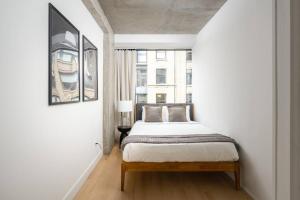 Habitación blanca con cama y ventana en Stunning Penthouse in Chelsea en Nueva York