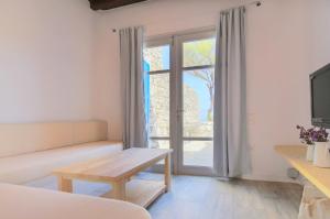 a living room with a couch and a tv at Villa Phaedra by Whitelist Mykonos in Agios Ioannis Mykonos