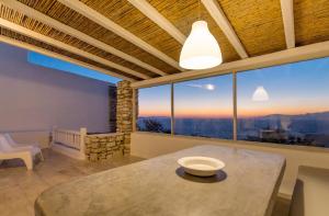 a room with a table and a large window with a view at Villa Phaedra by Whitelist Mykonos in Agios Ioannis Mykonos