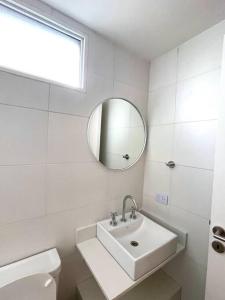 Baño blanco con lavabo y espejo en Departamento a estrenar con pileta y gimnasio en Buenos Aires