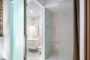 een badkamer met een toilet en een wastafel bij Apartamentos Málaga Centro El Conde by Renthas in Málaga
