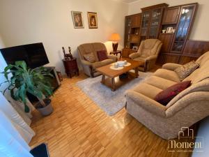 a living room with a couch and chairs and a table at Moment Apartman Vrsac in Vršac