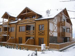a log cabin in the snow with snow at SKI&SUN - Apartmán B11 in Liptovský Mikuláš