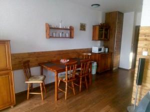 a kitchen with a table and chairs in a room at SKI&SUN - Apartmán B11 in Liptovský Mikuláš
