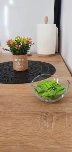 a glass bowl on a table with a vase of flowers at Studio Harmony Techirghiol in Techirghiol