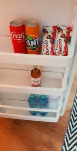 a refrigerator shelf with drinks and snacks in it at Studio Harmony Techirghiol in Techirghiol