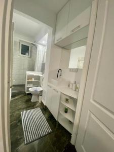 a white bathroom with a toilet and a sink at EDA apartment in Bistriţa
