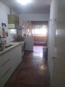 cocina con armarios blancos y suelo en Casaa bella en cba capital en Córdoba