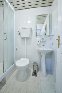 a white bathroom with a toilet and a sink at Hotel Podostrog in Budva