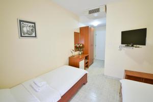 a hotel room with a bed and a television at Hotel Podostrog in Budva