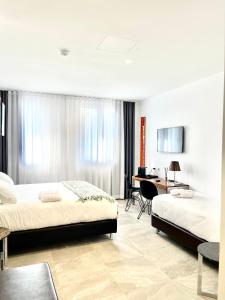 a hotel room with two beds and a desk at Le Muraine in Bergamo