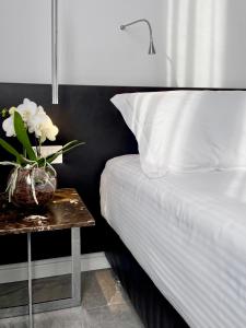 Una cama con una mesa con un jarrón de flores. en Le Muraine en Bérgamo