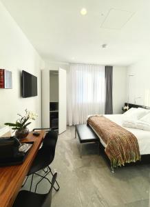 Habitación de hotel con cama y escritorio en Le Muraine, en Bérgamo