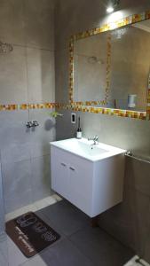 een badkamer met een witte wastafel en een spiegel bij El Aguaribay casa de montaña in Cortaderas