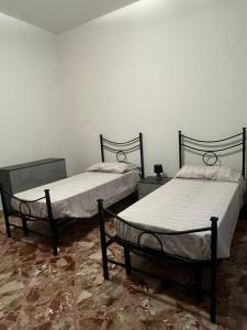 twee bedden in een kamer met een vloer bij A casa di Mary in Calimera