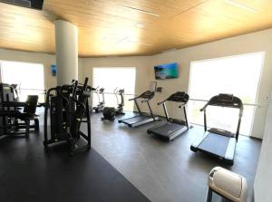 einen Fitnessraum mit mehreren Laufbändern in einem Zimmer in der Unterkunft 2bdr, Beach front Luxury Sunset view Heated Pools /Gym in Puerto Vallarta