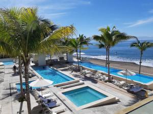 ein Luftblick auf ein Resort mit einem Pool und Palmen in der Unterkunft 2bdr, Beach front Luxury Sunset view Heated Pools /Gym in Puerto Vallarta