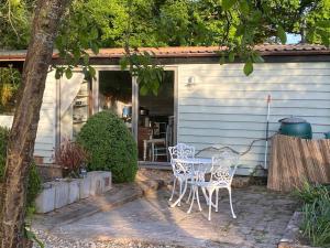 eine Terrasse mit einem Tisch und Stühlen vor einem Haus in der Unterkunft The Nutshell. Rural retreat in Pluckley