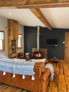 ein Wohnzimmer mit einem Sofa und einem Kamin in der Unterkunft The Nutshell. Rural retreat in Pluckley