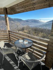 stół i krzesła na balkonie z widokiem w obiekcie Cabana Panorama Piscului Valea Doftanei w mieście Teşila