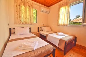 deux lits dans une chambre avec deux fenêtres dans l'établissement Anemelo house by the Kontogialos beach, à Pelekas