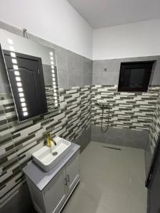 W łazience znajduje się umywalka i prysznic. w obiekcie Cabana Panorama Piscului Valea Doftanei w mieście Teşila