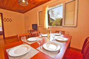 une salle à manger avec une table avec des assiettes et des verres à vin dans l'établissement Anemelo house by the Kontogialos beach, à Pelekas 20 autres photos