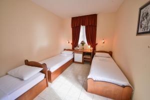 een hotelkamer met 2 bedden en een bureau bij Hotel Podostrog in Budva