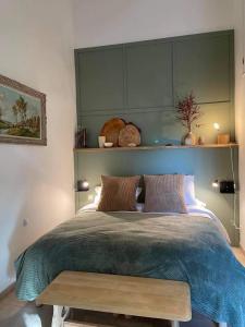 a bedroom with a large bed with a wooden bench at chambre d'hôtes Sauge Chez Brunet in Lagraulet-du-Gers