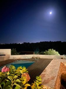 a house with a swimming pool at night at Casinha da Aldeia - country house with swimming pool in Santarém