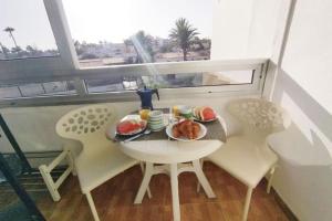 un tavolo con un piatto di cibo su un balcone di koka terraced accommodation a Maspalomas